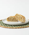 A Lehto's chicken pasty cut in half, showing the chicken and vegetable filling inside the golden crust.